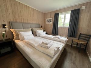 een slaapkamer met een groot bed en handdoeken bij Vågåvatnet Feriesenter in Vågåmo