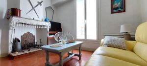 ein Wohnzimmer mit einem gelben Sofa und einem Tisch in der Unterkunft La miellerie de Léone in Riez
