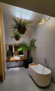 ein Badezimmer mit einer Badewanne und Topfpflanzen in der Unterkunft In Real Life in Khu Chi Lăng