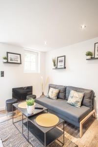 ein Wohnzimmer mit einem Sofa und 2 Tischen in der Unterkunft La villa MaRisKa et son SPA in Ouistreham