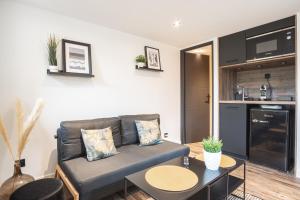 ein Wohnzimmer mit einem Sofa und einem Tisch in der Unterkunft La villa MaRisKa et son SPA in Ouistreham