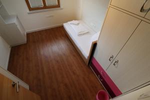 Camera piccola con letto e pavimento in legno. di Ferienhotel Fuchs a Söll