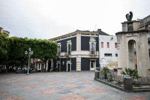 een lege straat met een zwart-wit gebouw bij MAZZINI PALACE in Misterbianco