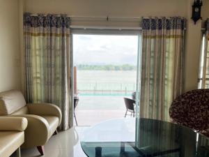 a living room with a glass table in front of a window at BaanJergun-บ้านเจอกัน in Nakhon Phanom