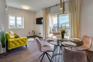 een woonkamer met een eettafel en een gele bank bij TEONA Luxury Apartment with 2 rooms and terrace sea view in Sali