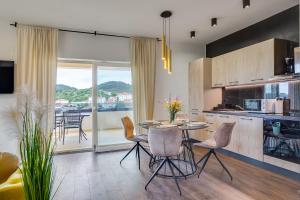 een keuken en eetkamer met een tafel en stoelen bij TEONA Luxury Apartment with 2 rooms and terrace sea view in Sali