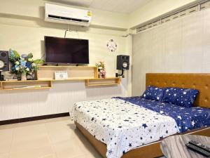 a bedroom with a bed and a flat screen tv at BaanJergun-บ้านเจอกัน in Nakhon Phanom