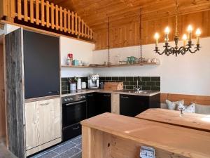 eine Küche mit schwarzen Geräten und einer Holzdecke in der Unterkunft Rossweid Huette in Stans
