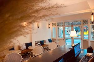 una camera con sedie e tavolo con computer portatile di Forgotten Hostel Silom a Bang Rak