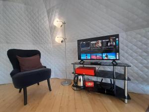 a living room with a chair and a television at Glamping Domes San Martino in Itri