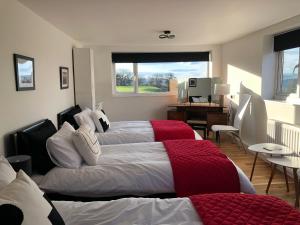 um quarto com 2 camas, uma secretária e uma janela em Black Mountain Views em Velindre