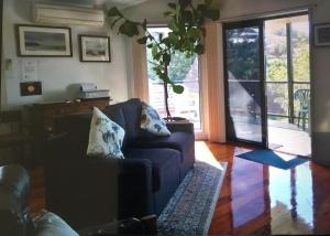 a living room with a couch and a sliding glass door at Strathmore Lodge in Port Macquarie