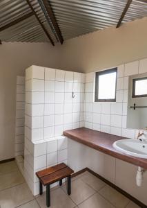 a bathroom with a sink and a wooden bench at Onguma Tamboti Campsite in Namutoni
