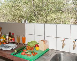 - un comptoir de cuisine avec une planche de coupe et de la nourriture dans l'établissement Onguma Tamboti Campsite, à Namutoni