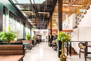 a restaurant with tables and chairs and potted plants at Riverside International Youth Hostel阅江老院青年旅舍 in Chongqing