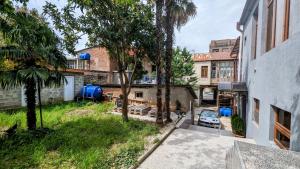 an apartment with a yard with a car parked in it at Nickos Hotel in Kutaisi