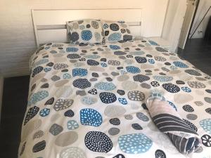 a bed with a blue and white comforter and pillows at Nice Entire Semi - Attached House - B in Umeå
