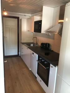 a kitchen with white cabinets and a black counter top at Nice Entire Semi - Attached House - B in Umeå