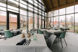 a restaurant with tables and chairs and large windows at PIRA HOTEL in Postojna