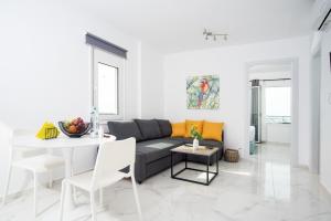 Athinais Suites في خيرسونيسوس: غرفة معيشة مع أريكة وطاولة