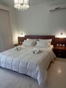 a large white bed with two stuffed animals on it at DM Villa - quality stay in Perea, Thessaloniki, Greece in Perea