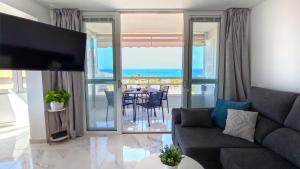 a living room with a couch and a view of the ocean at AZURE VIEW Ponderosa 719 in Playa Fañabe