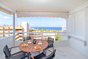 a table and chairs on a balcony with a view of the ocean at AZURE VIEW Ponderosa 719 in Playa Fañabe