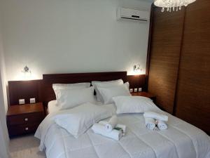 a bedroom with a large white bed with towels on it at DM Villa - quality stay in Perea, Thessaloniki, Greece in Perea +17 photos