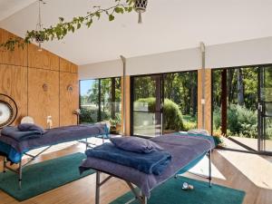 two beds in a room with large windows at Simala Retreat in Cowaramup