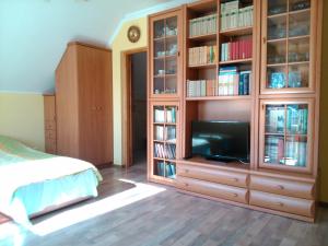 una camera da letto con un grande centro di intrattenimento in legno con televisore di Charbrowski Młyn a Wicko