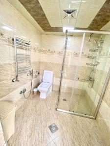 a bathroom with a shower and a toilet and a glass shower stall at House in Quba in Quba