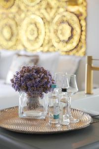 un plateau avec un vase de fleurs et deux verres dans l'établissement Pafsilipon Suites, à Ermoúpoli