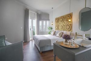 een slaapkamer met een bed, een tafel en een spiegel bij Pafsilipon Suites in Ermoupoli