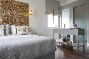 a bedroom with a bed and a table and a sink at Pafsilipon Suites in Ermoupoli