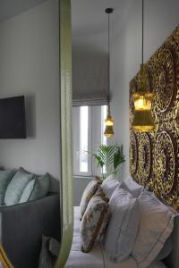 a bedroom with a bed and a couch and a mirror at Pafsilipon Suites in Ermoupoli