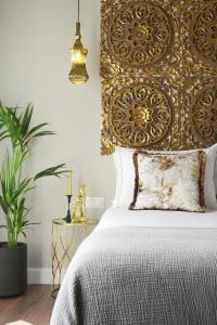a bedroom with a bed with a gold headboard at Pafsilipon Suites in Ermoupoli