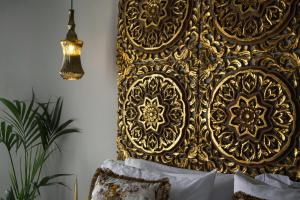 a wall with a gold headboard in a room at Pafsilipon Suites in Ermoupoli