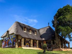 a house with a thatched roof at Addo Bush Palace in Addo