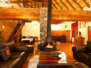 a living room with a couch and a fireplace at Addo Bush Palace in Addo