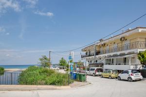 a building with cars parked in front of the ocean at PeramoBello in Nea Peramos