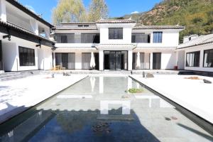 una casa con piscina di fronte a un edificio di Gong Xili Qingdu Hotel a Shangri-La