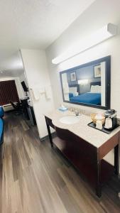 a bathroom with a sink and a large mirror at Pinckneyville Inn and Suites in Pinckneyville