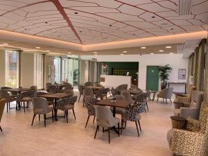 - un restaurant avec des tables et des chaises dans une salle dans l'établissement Domitys Les Cépages, à Gaillac