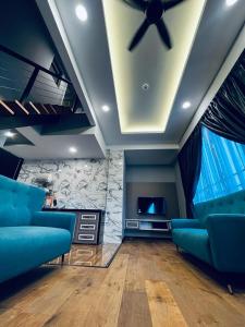 sala de estar con sillas azules y ventilador de techo en LAVIE HOTEL & APARTMENT, en Brinchang