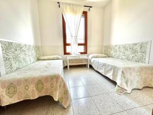 2 letti in una camera con finestra di Sunny terrace apartament a Cavallino-Treporti