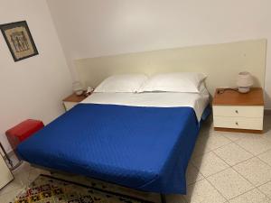 ein blaues und weißes Bett in einem kleinen Zimmer in der Unterkunft Case vacanze Dalia in Torregrotta