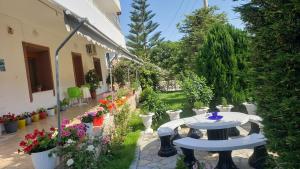 - un patio avec une table et des fleurs dans la cour dans l'établissement Vila Renato Ksamil, à Ksamil