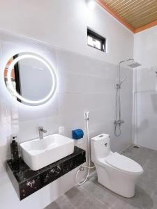 bagno con lavandino, servizi igienici e specchio di Thuy Tien Ecolodge a Cat Tien