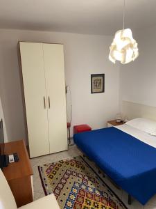 1 dormitorio con 1 cama azul y armario blanco en Case vacanze Dalia, en Torregrotta