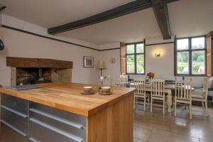 a kitchen and dining room with a fireplace at Canons Court Lodge in Wotton-under-Edge